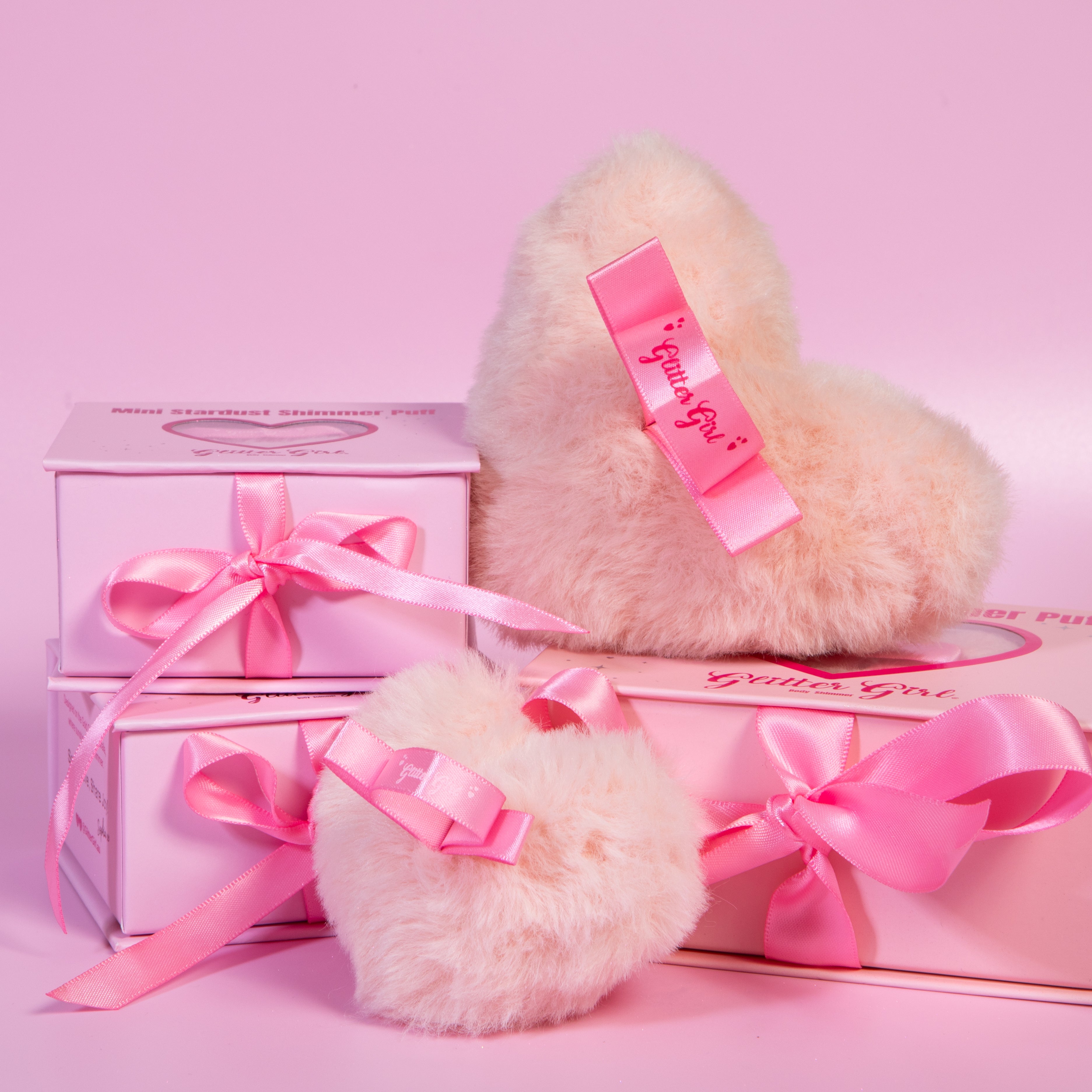 Full-size bronze Stardust Love Heart Shimmer Puff beside the travel-sized baby pink Mini