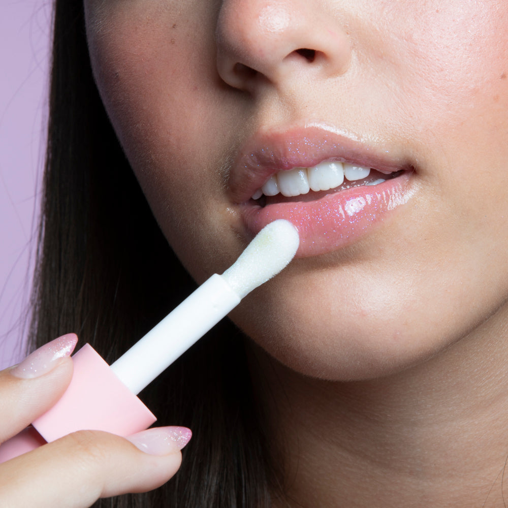 Close-up of a teen girl applying Glitter Girl Lip Gloss, creating a shimmering, dewy lip effect.